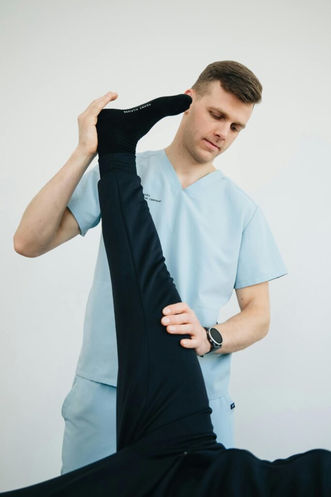 pexels-photo-20860584-20860584 Professional physiotherapist helping a patient with leg exercises in a clinic setting.